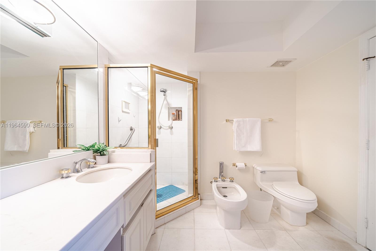 6301 Collins Avenue, Unit 2802 Miami Beach, FL 33141 - Photo 20 of 28 a bathroom with a granite countertop sink a toilet and a large mirror