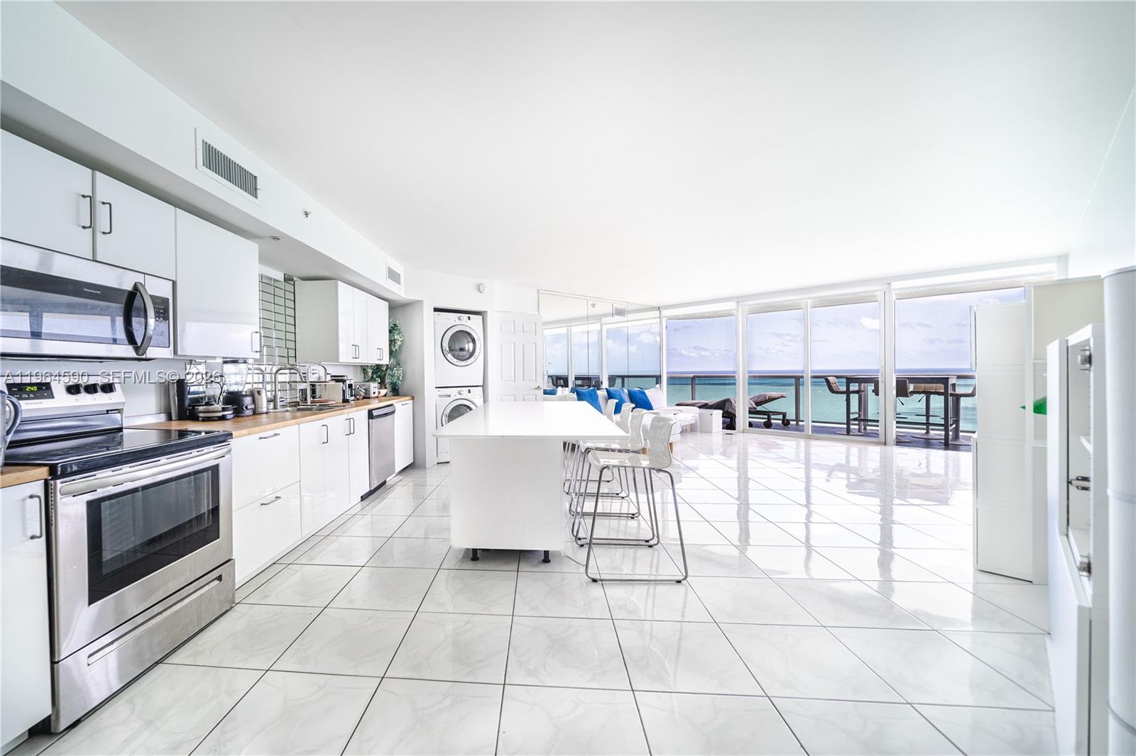 6301 Collins Avenue, Unit 2802 Miami Beach, FL 33141 - Photo 3 of 28 a living room with stainless steel appliances furniture a rug and a kitchen view
