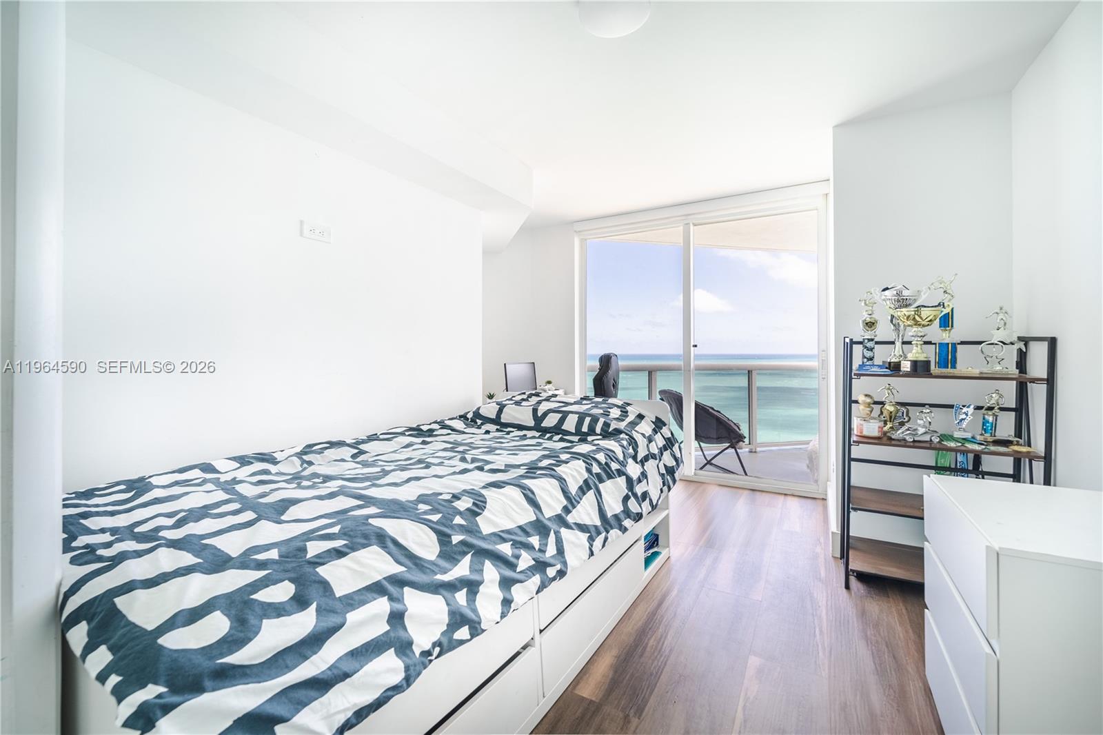6301 Collins Avenue, Unit 2802 Miami Beach, FL 33141 - Photo 10 of 28 a bedroom with a bed and a table