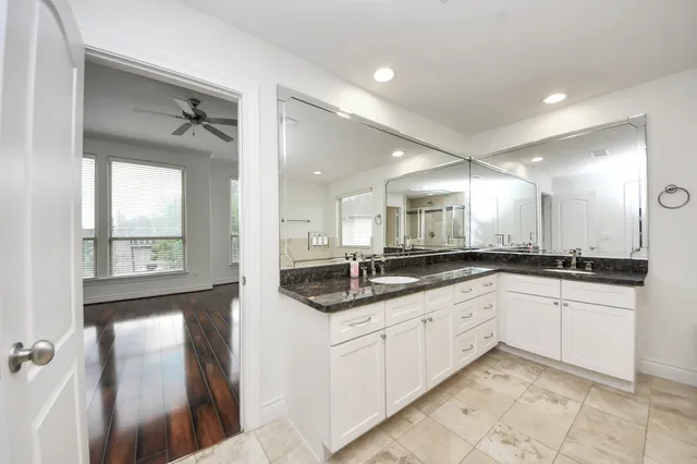 a large bathroom with a granite countertop sink and a mirror