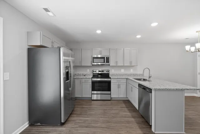 a kitchen with stainless steel appliances granite countertop a refrigerator and a stove top oven