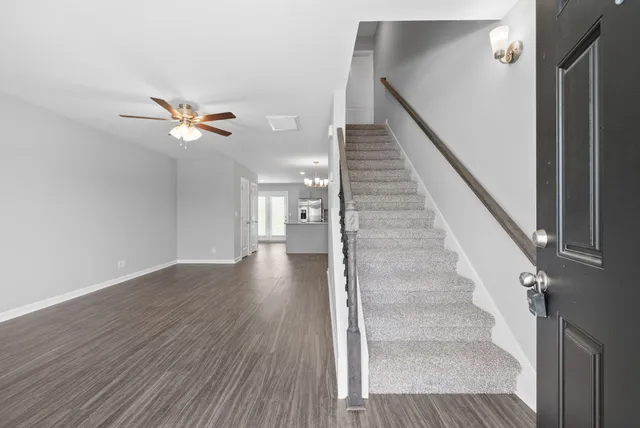 a view of staircase with wooden floor and white walls