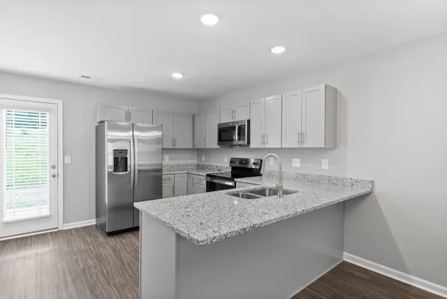 a kitchen with stainless steel appliances granite countertop a sink refrigerator and microwave