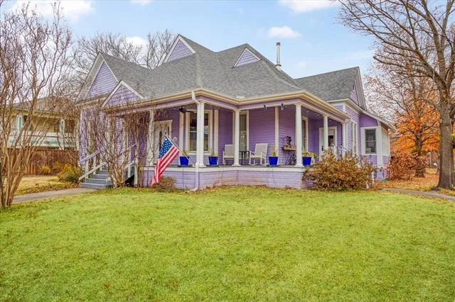 a view of a house with a big yard and a large tree
