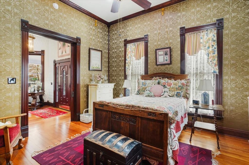 300 West 6th Street Bonham, TX 75418 - Photo 16 of 40 a bedroom with a bed and wooden floor