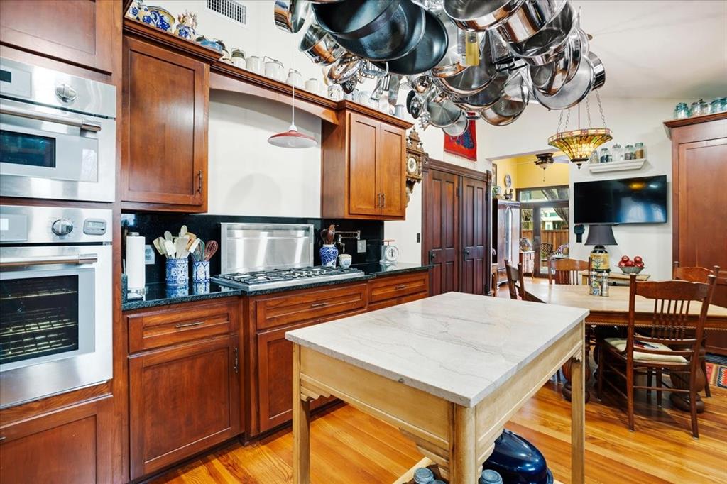 300 West 6th Street Bonham, TX 75418 - Photo 25 of 40 a kitchen with stainless steel appliances granite countertop a sink a stove and a wooden cabinets