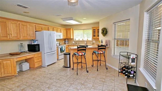 a kitchen with stainless steel appliances kitchen island granite countertop a refrigerator and a stove