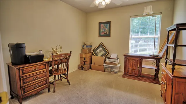 a view of a workspace with furniture and a window