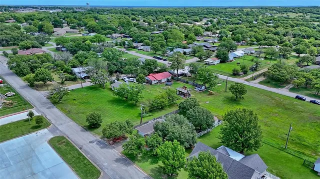 an aerial view of residential houses with outdoor space and trees