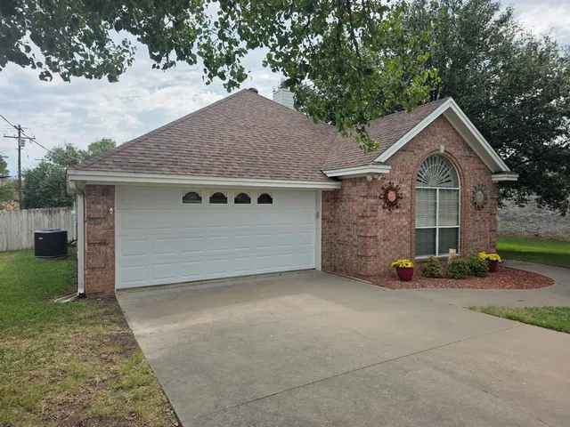 a view of a house with a yard and large tree