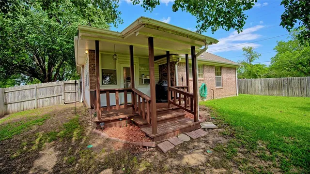 a view of a chair and table in backyard of the house