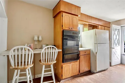 a kitchen with stainless steel appliances a refrigerator and a fireplace