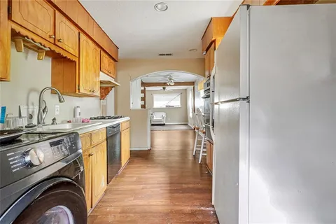 a view of a kitchen with stainless steel appliances granite countertop a refrigerator and a stove