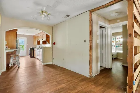 a view of a hallway with wooden floor and a kitchen