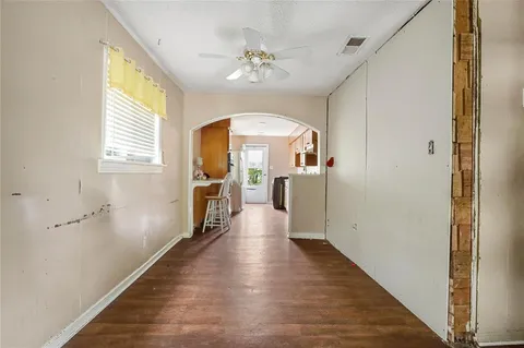 a view of a hallway with wooden floor and a living room