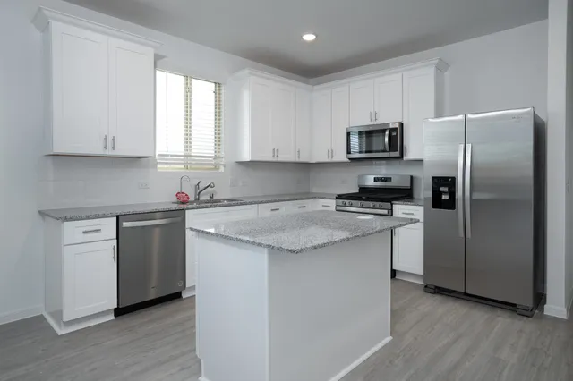 a kitchen with a refrigerator sink and cabinets