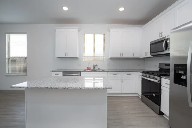 a kitchen with granite countertop a sink and steel appliances