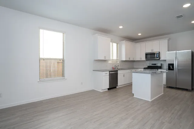 a kitchen with a refrigerator and a stove top oven