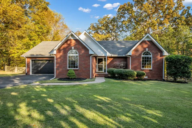 a front view of a house with a garden and yard