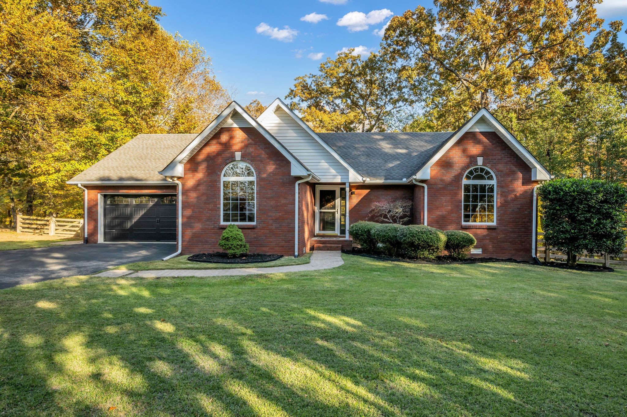 a front view of a house with a garden and yard