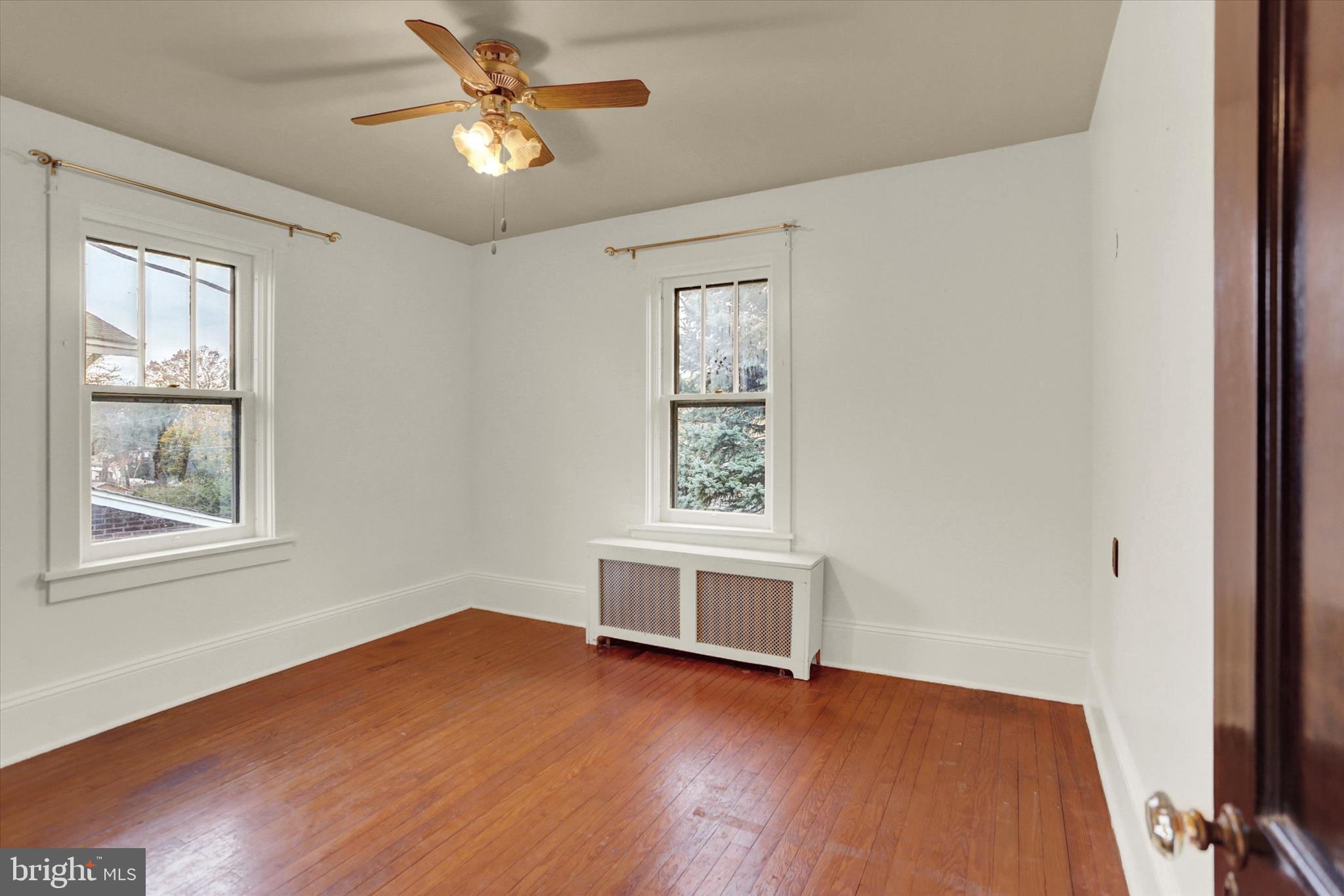 711 Pine Street Steelton, PA 17113 - Photo 21 of 37 an empty room with wooden floor chandelier fan and windows