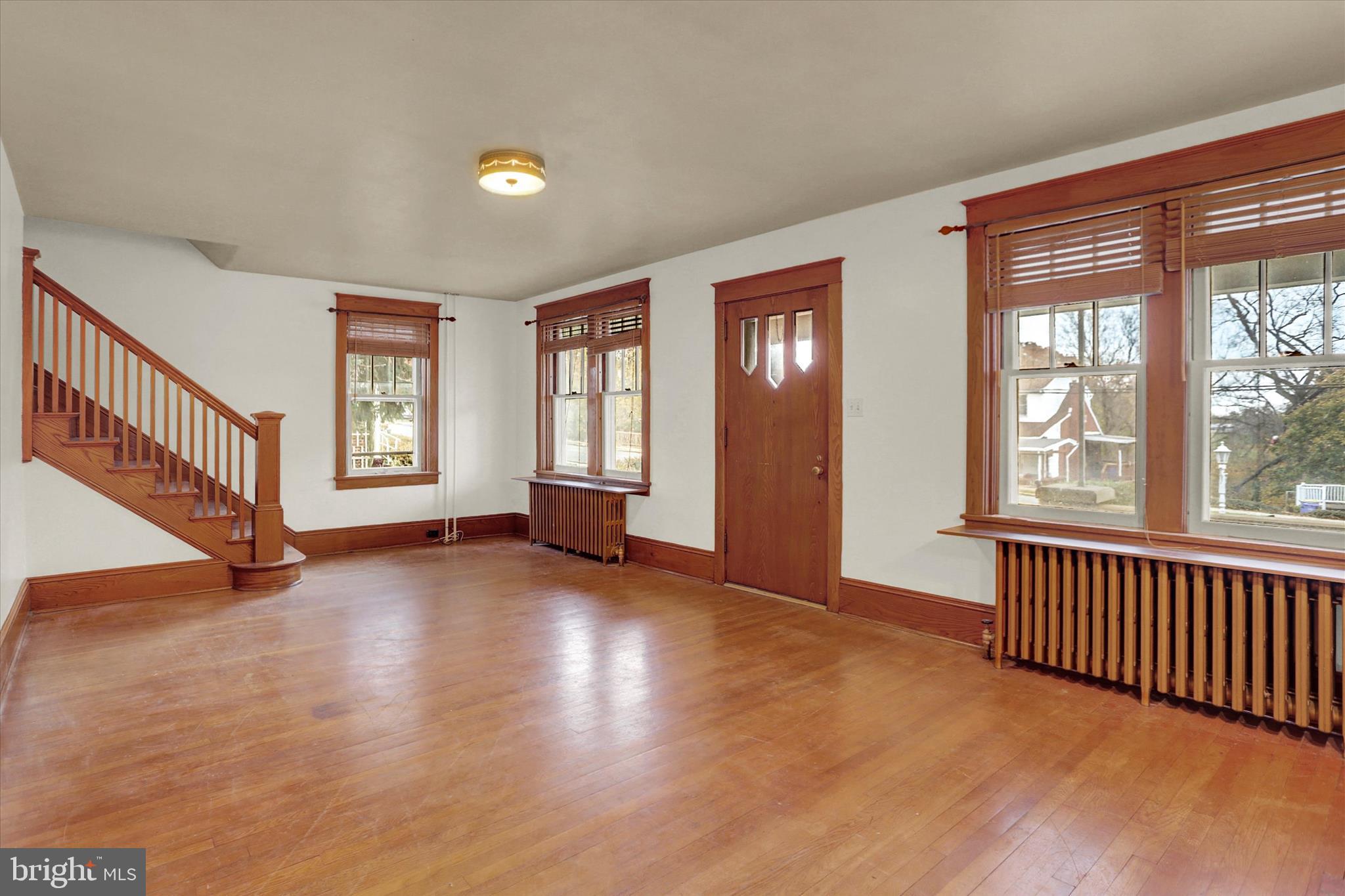 711 Pine Street Steelton, PA 17113 - Photo 6 of 37 a view of an empty room with a window and wooden floor