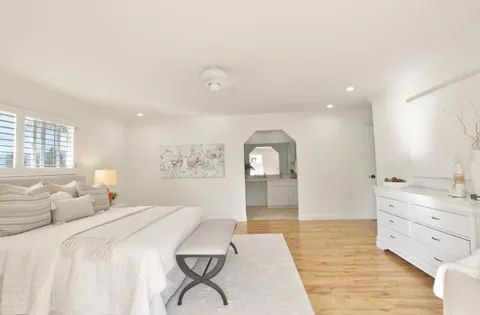 a spacious bedroom with a bed and a dresser