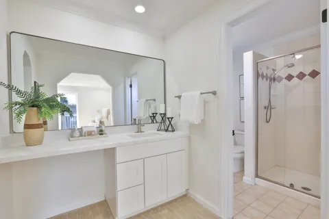 a bathroom with a double vanity sink mirror and shower