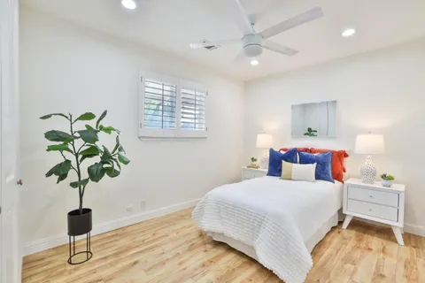 a bedroom with a bed and wooden floor