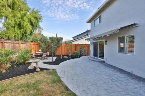 a view of a house with backyard and sitting area