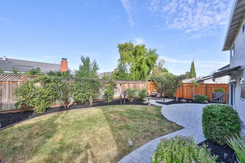 a view of a house with backyard and a tree