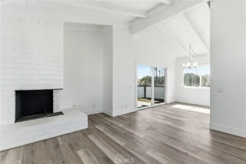 an empty room with wooden floor and fireplace