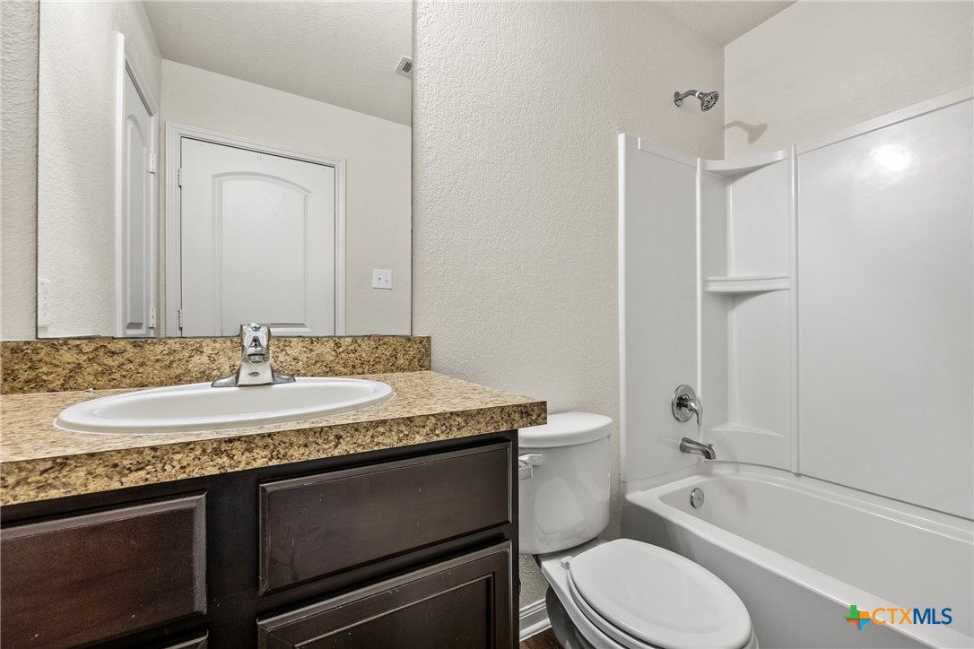 137 Bridges Lane Jarrell, TX 76537 - Photo 22 of 34 a bathroom with a granite countertop sink toilet and shower