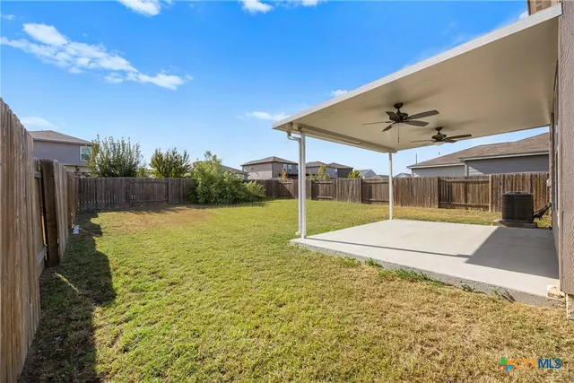 a view of a house with backyard and sitting area