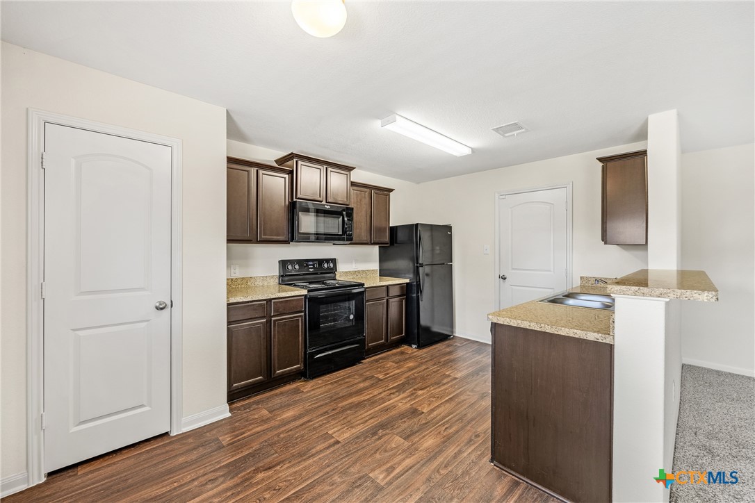 137 Bridges Lane Jarrell, TX 76537 - Photo 8 of 34 a kitchen with stainless steel appliances granite countertop a sink stove and refrigerator
