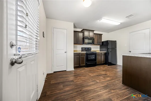 a kitchen with stainless steel appliances granite countertop a refrigerator a stove top oven a sink and dishwasher