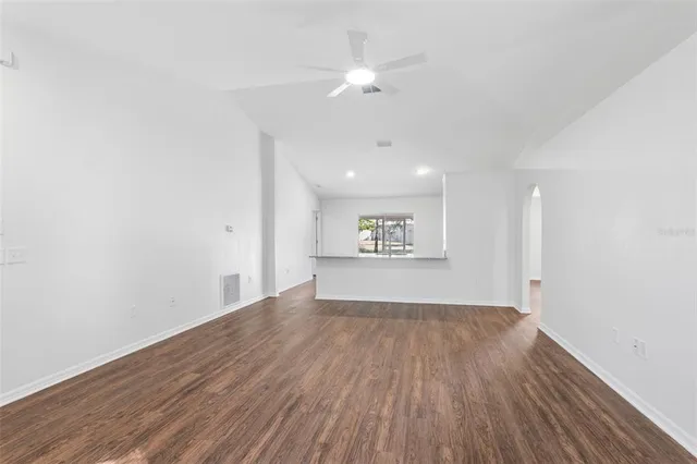 a view of a room with wooden floor and a ceiling fan