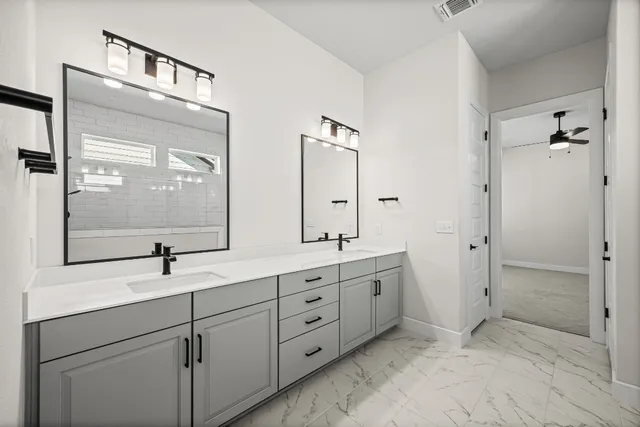 a bathroom with a double vanity sink and mirror