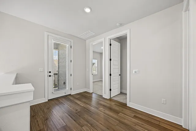 a view of a livingroom with wooden floor and bathroom