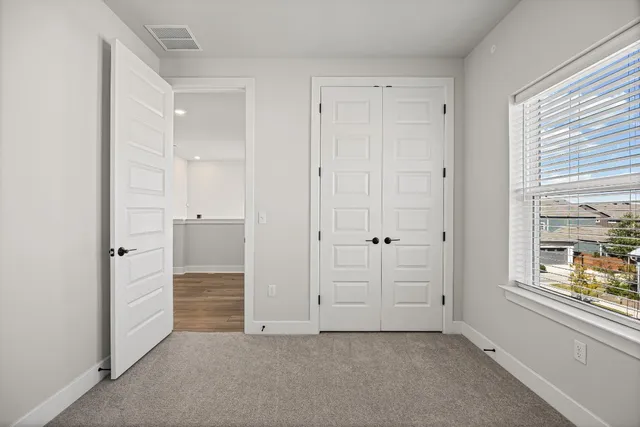 an empty room with windows and closet