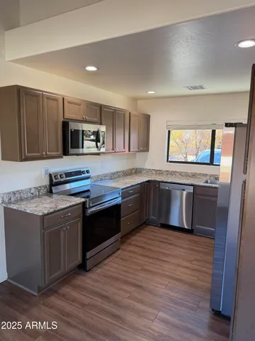 a kitchen with granite countertop a refrigerator and a sink