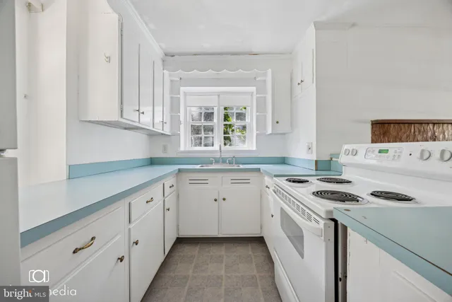 a kitchen with granite countertop a sink stove and cabinets