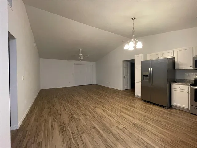 wooden floor in an empty room with a kitchen
