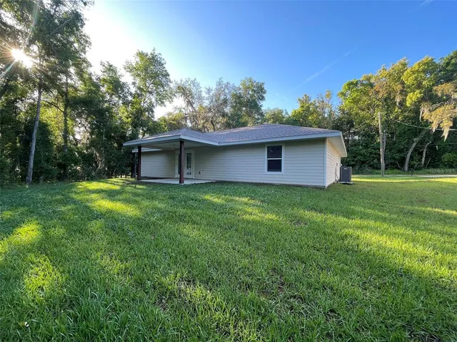 a front view of house with garden and trees