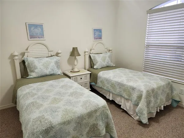 a bedroom with two beds and painting on the wall