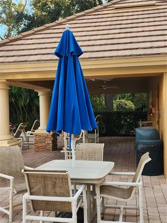 a view of a patio with table and chairs under an umbrella