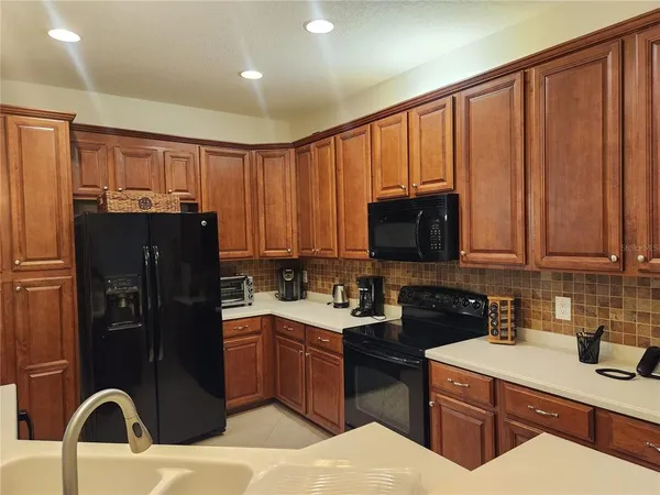 a kitchen with a sink refrigerator and cabinets