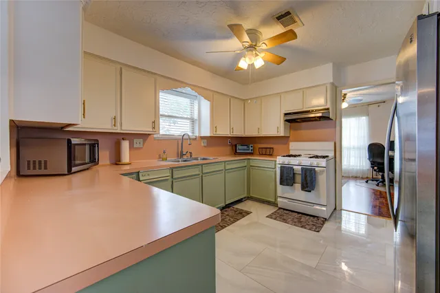 a kitchen with a refrigerator and a stove top oven