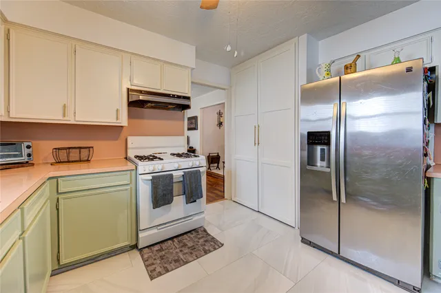 a kitchen with a refrigerator sink and cabinets