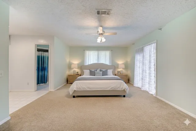 a spacious bedroom with a bed and a chandelier
